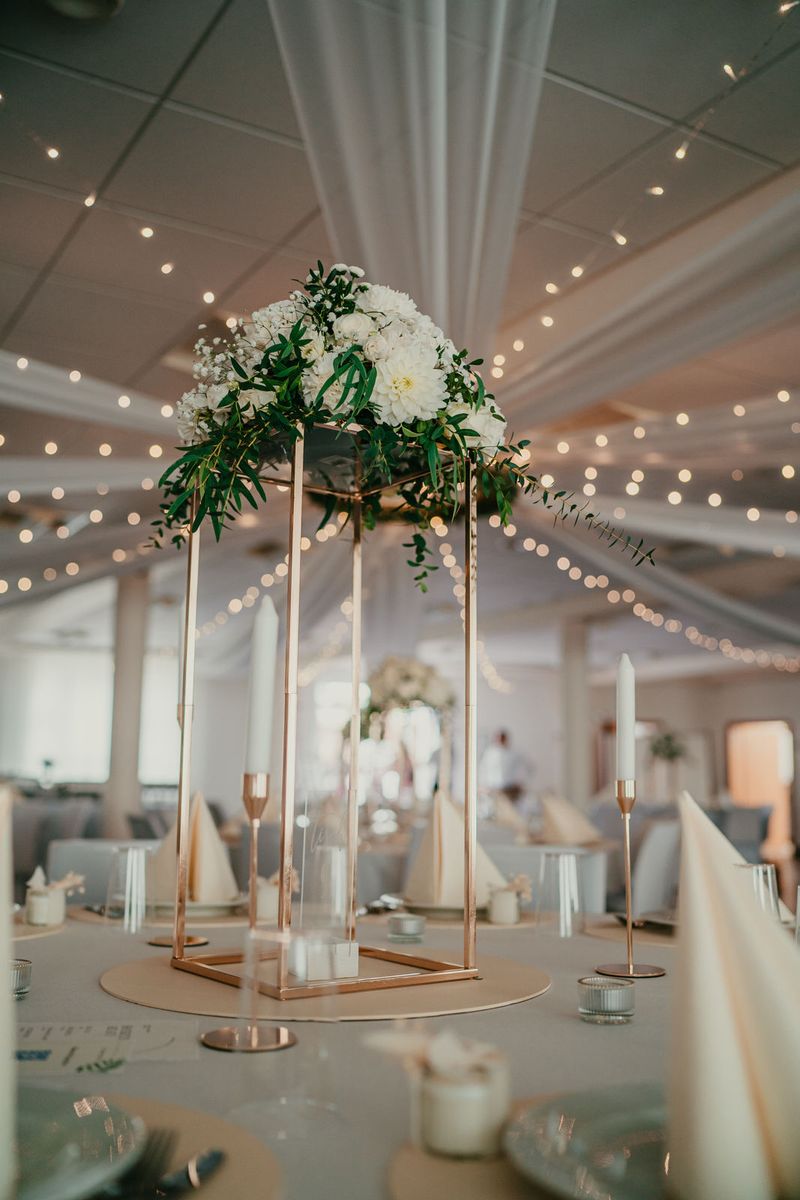 Goldene Blumenständer auf der Hochzeitstafel